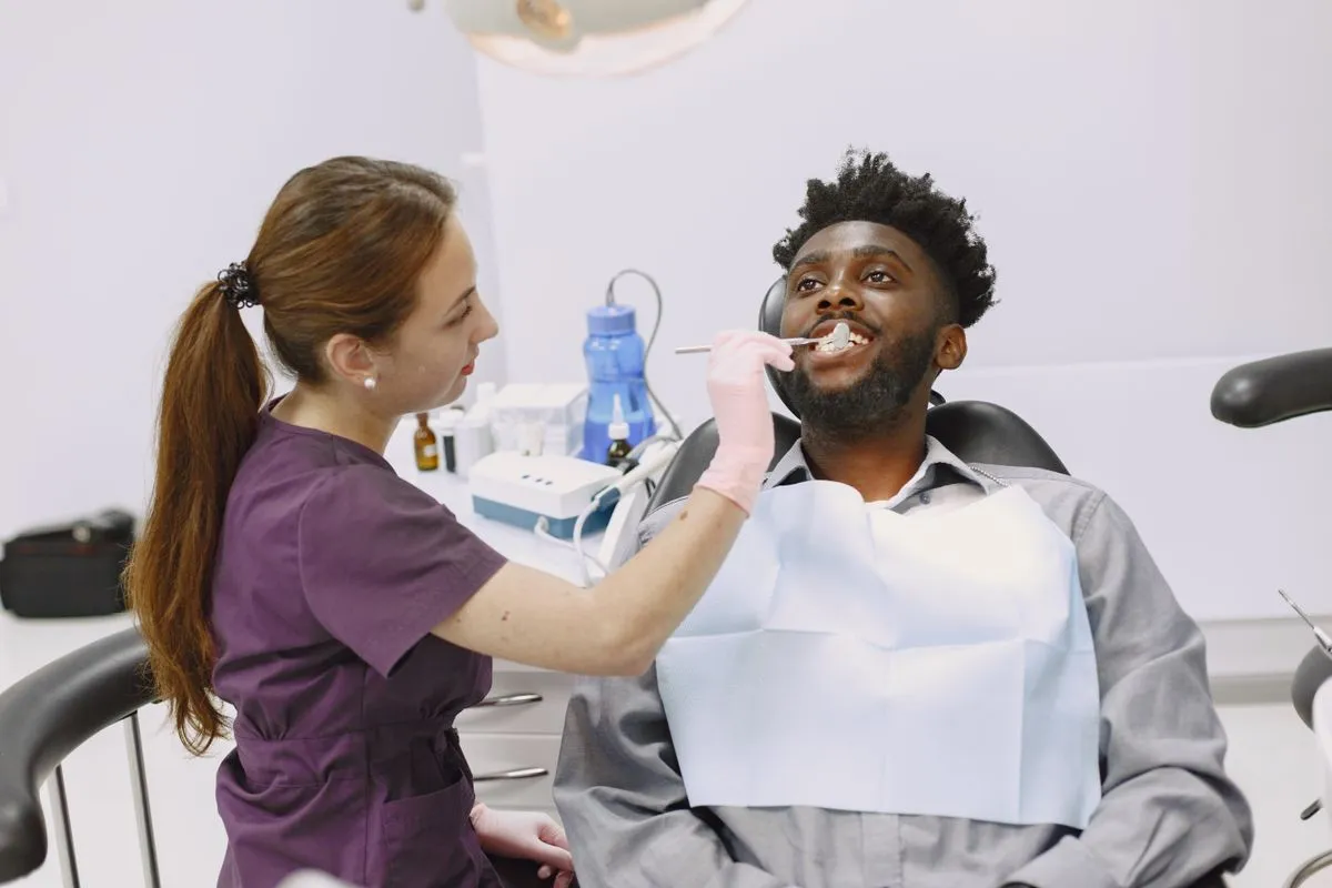 A dentist examining a patient's teeth during an urgent visit